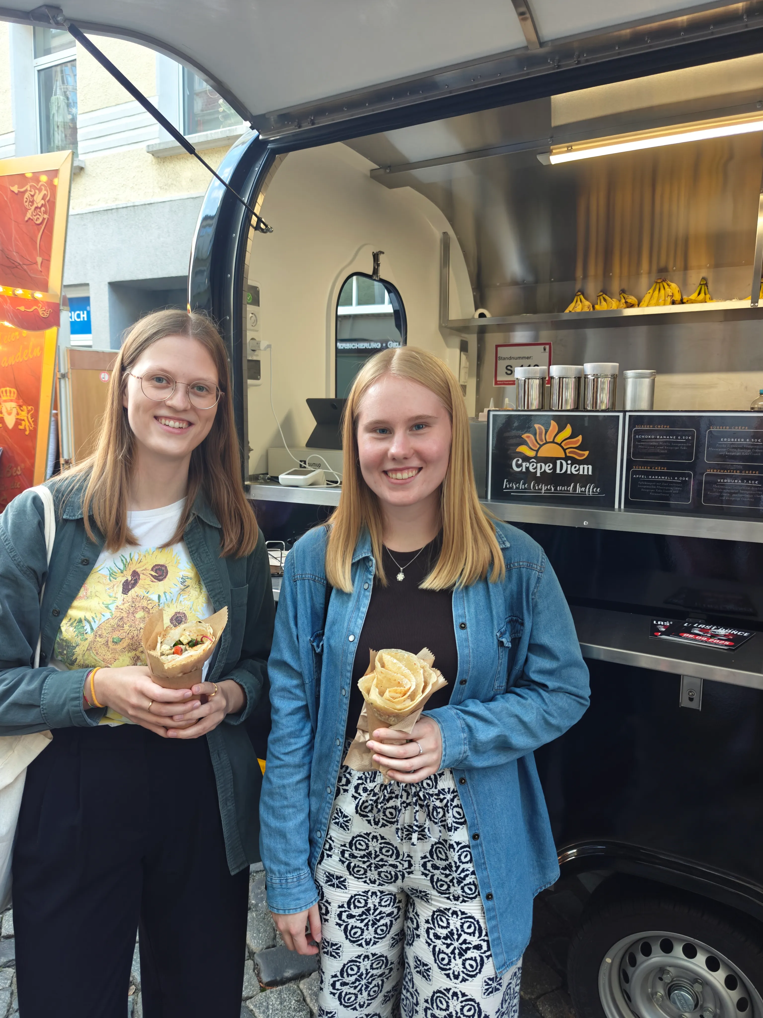 Zwei zufriedene Kundinnen mit Crêpe Rolls vor dem Crêpe Diem Foodtruck